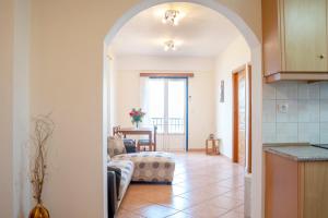 a living room with an archway leading to a kitchen at Mairoula apartments! in Koroni