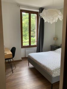 een slaapkamer met een bed, een bureau en een raam bij L'AUBERGE DE LA GOUTILLE in Capvern