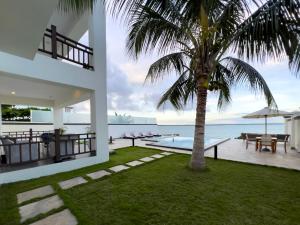 a house with a palm tree and a swimming pool at Zanzibar DT Beachfront Villa in Mkunguni