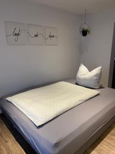 - un lit dans une chambre avec 2 photos sur le mur dans l'établissement Ferienwohnung Jasmin, à Neustadt an der Weinstraße