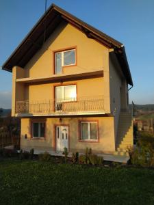 a yellow house with a balcony on the side of it at Apartman Vera in Kremna