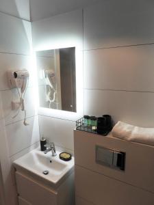 a white bathroom with a sink and a mirror at Apartament Na Dworcu in Jedlina-Zdrój