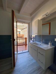 a bathroom with a sink and a view of a deck at Appartamenti Le Tre Rose in Nago-Torbole