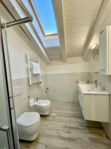a bathroom with a toilet and a sink and a skylight at Appartamenti Le Tre Rose in Nago-Torbole +19 photos