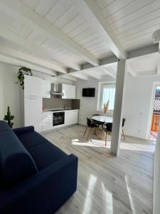 a living room with a blue couch and a table at Appartamenti Le Tre Rose in Nago-Torbole