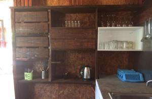 a kitchen with wooden cupboards and a sink with glasses at Cabaña de madera para 4 personas in Playa Hermosa +7 photos