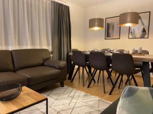 uma sala de estar com um sofá, uma mesa e cadeiras em Apartment Via Surpunt - Signal - 5 Rooms em St. Moritz