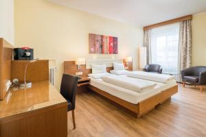 a hotel room with a bed and a desk and a desk at Hotel Weißes Kreuz in Bregenz