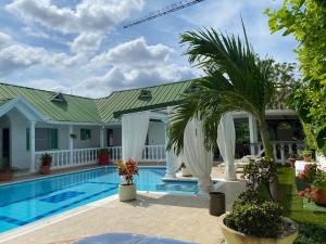 una casa con una piscina y una palmera en Casa en Girardot en Ricaurte
