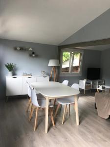 uma sala de jantar com uma mesa branca e cadeiras em Le Balcon d’Echery em Sainte-Marie-aux-Mines