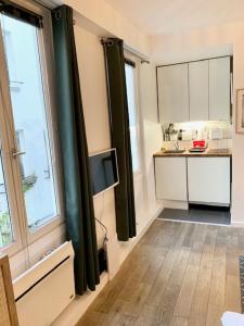 um quarto com uma cozinha com um lavatório e janelas em Cosy Studio in Montorgueil em Paris