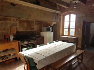 kuchnia ze stołem, kuchenką, stołem i krzesłami w obiekcie Demeure pittoresque en pierres 1741 - 3 étoiles - 12 personnes w mieście Arpenans