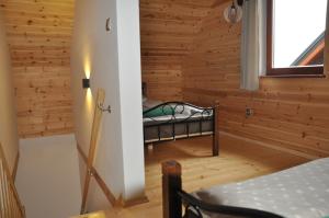 a bedroom in a log cabin with a bed in it at BEY Domki całoroczne in Sztutowo