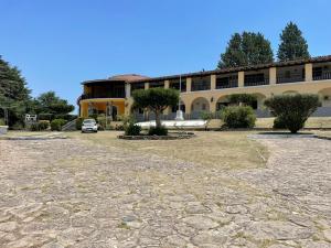 un gran edificio con un coche aparcado delante de él en Complejo Turistico - Hotel Pinar serrano - Bialet Masse - Cordoba en Bialet Massé