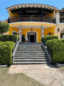 uma casa amarela com escadas em frente em Complejo Turistico - Hotel Pinar serrano - Bialet Masse - Cordoba em Bialet Massé