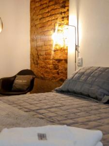 a bedroom with a bed and a brick wall at Encanto do Pilar in Ouro Preto