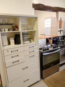 a kitchen with white cabinets and a stove at Encanto do Pilar in Ouro Preto