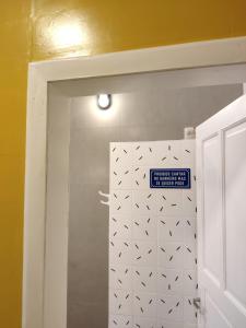 a bathroom door with a sign on the wall at Encanto do Pilar in Ouro Preto
