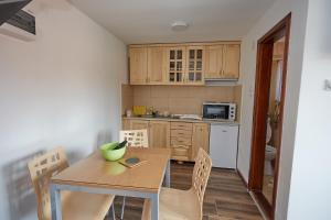 a small kitchen with a wooden table and chairs at Apartmani ,,Vasa ,, 1 in Soko Banja