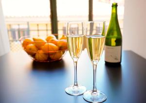 two glasses of champagne and a bowl of oranges on a table at L´Aguila Suites - Turismo de Interior in Palma de Mallorca