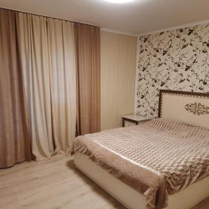 ein Schlafzimmer mit einem Bett und einer Blumenwand in der Unterkunft Карпатьські зорі in Werchowyna