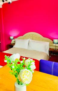 1 dormitorio con 1 cama y 1 mesa con flores en Departamentos Sobre el Mar en Villa Gesell