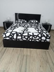 a bed with a black and white comforter in a bedroom at casa do mestre in Vieira do Minho