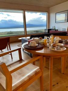 una mesa con comida en ella en una habitación con ventanas en Line Hotel Patagonia, en Puerto Natales