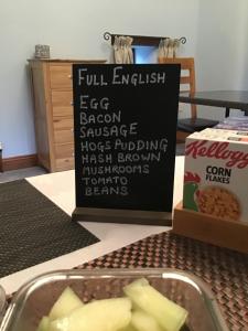 a sign and a bowl of food on a table at Owletts Barn B&B in Bodmin