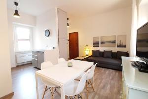 ein Wohnzimmer mit einem weißen Tisch und einem Sofa in der Unterkunft Uno sguardo sul mare - appartamento in Ancona
