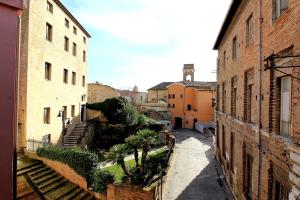 un callejón en una ciudad antigua con edificios y palmeras en Uno sguardo sul mare - appartamento en Ancona