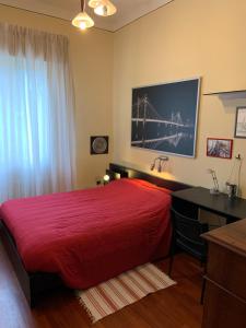 een slaapkamer met een groot rood bed en een bureau bij Casa di Anna in Ravenna