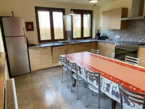 a kitchen with a table with chairs and a refrigerator at Maison de 6 chambres avec jardin clos et wifi a Sermersheim in Sermersheim