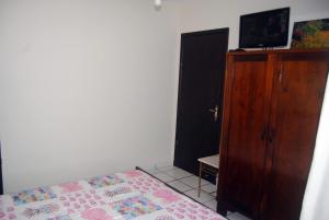 a bedroom with a bed and a wooden cabinet at Apto Meia Praia in Itapema