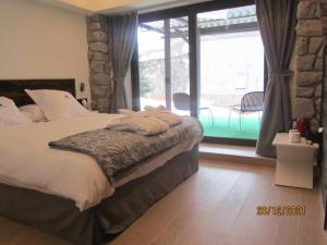 ein Schlafzimmer mit einem Bett und einem großen Fenster in der Unterkunft Mauberme Mountain Boutique Hotel in Salardú