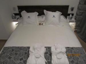 Una cama con zapatos blancos encima. en Mauberme Mountain Boutique Hotel, en Salardú