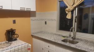 a kitchen with a sink and a window at Rubedo - Punta Fria in Piriápolis +8 photos