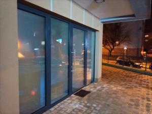eine Glasfassade eines Gebäudes in der Nacht in der Unterkunft Private Relax Armonia Wellness Apartment in Svit