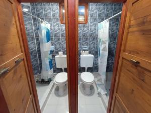 a bathroom with two toilets and a shower at Apartments & Rooms Vitko in Žabljak