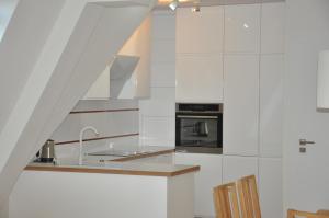 a kitchen with white cabinets and a stove top oven at Luksusowy 100 metrowy Apartament z klimatyzacją w Giżycku in Giżycko