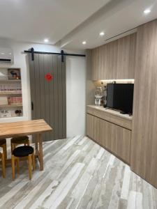 eine Küche mit einem Tisch und einem TV in einem Zimmer in der Unterkunft DayBreak 2 in Taitung