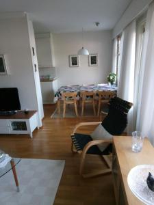 a living room with a table and a dining room at Cozy two room apartment with sauna in Hyvinkää
