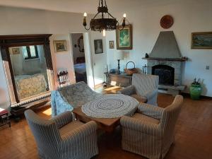 sala de estar con mesa, sillas y chimenea en Case La Sassa, en Marliana
