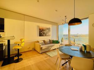 ein Wohnzimmer mit einem Tisch und einem Sofa in der Unterkunft TrIIIple Level 20 - Sonnenwohnen Apartment mit Parkplatz und fantastischem Ausblick in Wien