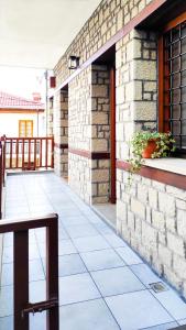 a brick building with a balcony with a table at Κάλλος-Kallos Apartment in Metsovo