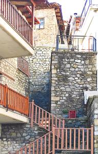 un edificio de piedra con escalera y pared de piedra en Κάλλος-Kallos Apartment, en Metsovo