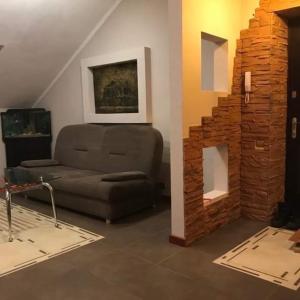 ein Wohnzimmer mit einem Sofa und einem gemauerten Kamin in der Unterkunft Затишна квартира в спальному районі in Lwiw