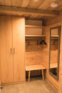 uma cabina de madeira com um banco num quarto em Ferienwohnung am Dorfbach em Rettenberg