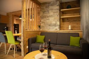 a living room with a couch and a table with wine glasses at Ferienwohnung am Dorfbach in Rettenberg