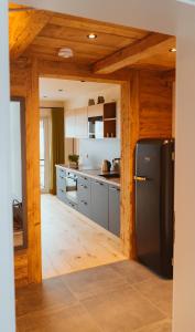 a kitchen with a black refrigerator in a room at Ferienwohnung am Dorfbach in Rettenberg